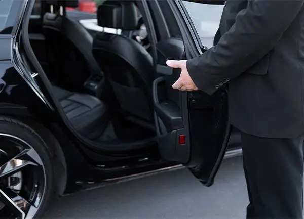 راننده در حال باز کردن در خودرو جهت سوار شدن کارفرما