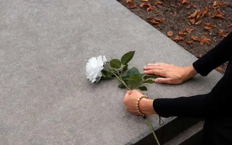 تصویر یک بانو در حال عزاداری بر روی سنگ قبر